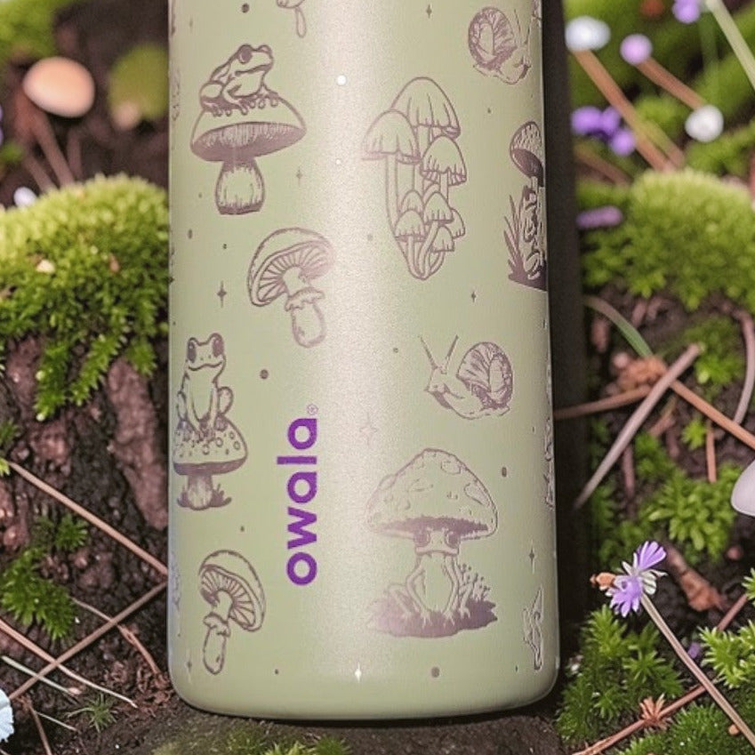 Green water bottle with mushroom design in a forest setting